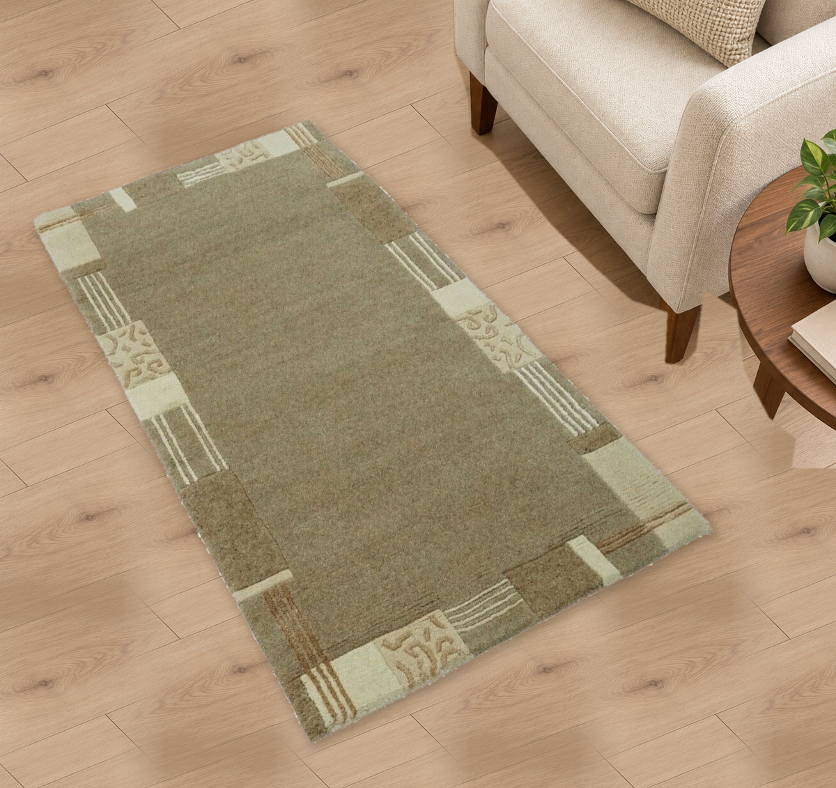Wollteppich N768 in Taupe und Beige mit Bordüre neben einem hellen Sessel – Wohnbeispiel